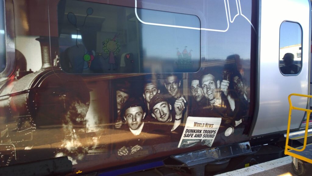 A modern railway carriage with a mural depicting troops travelling from Dunkirk