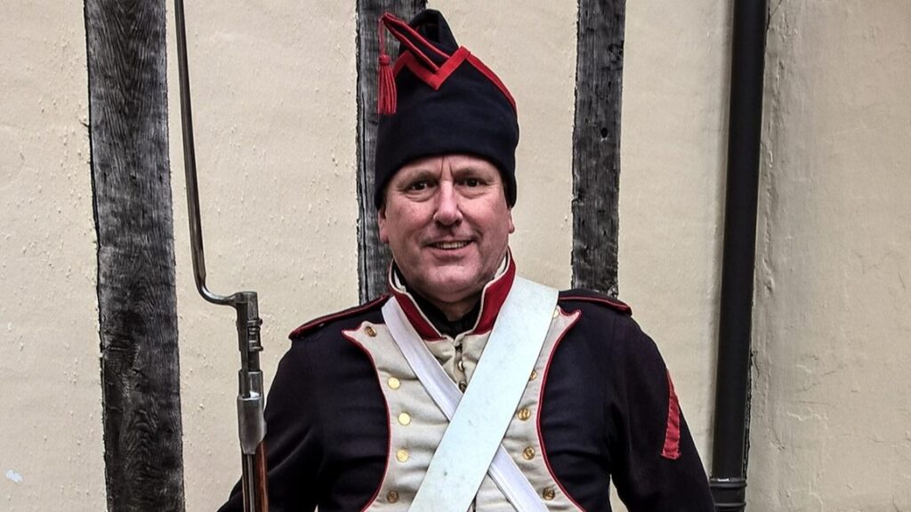 A reenactor in the uniform of a Napoleonic French soldier